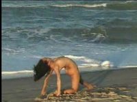 Обнаженная гимнастка на берегу моря